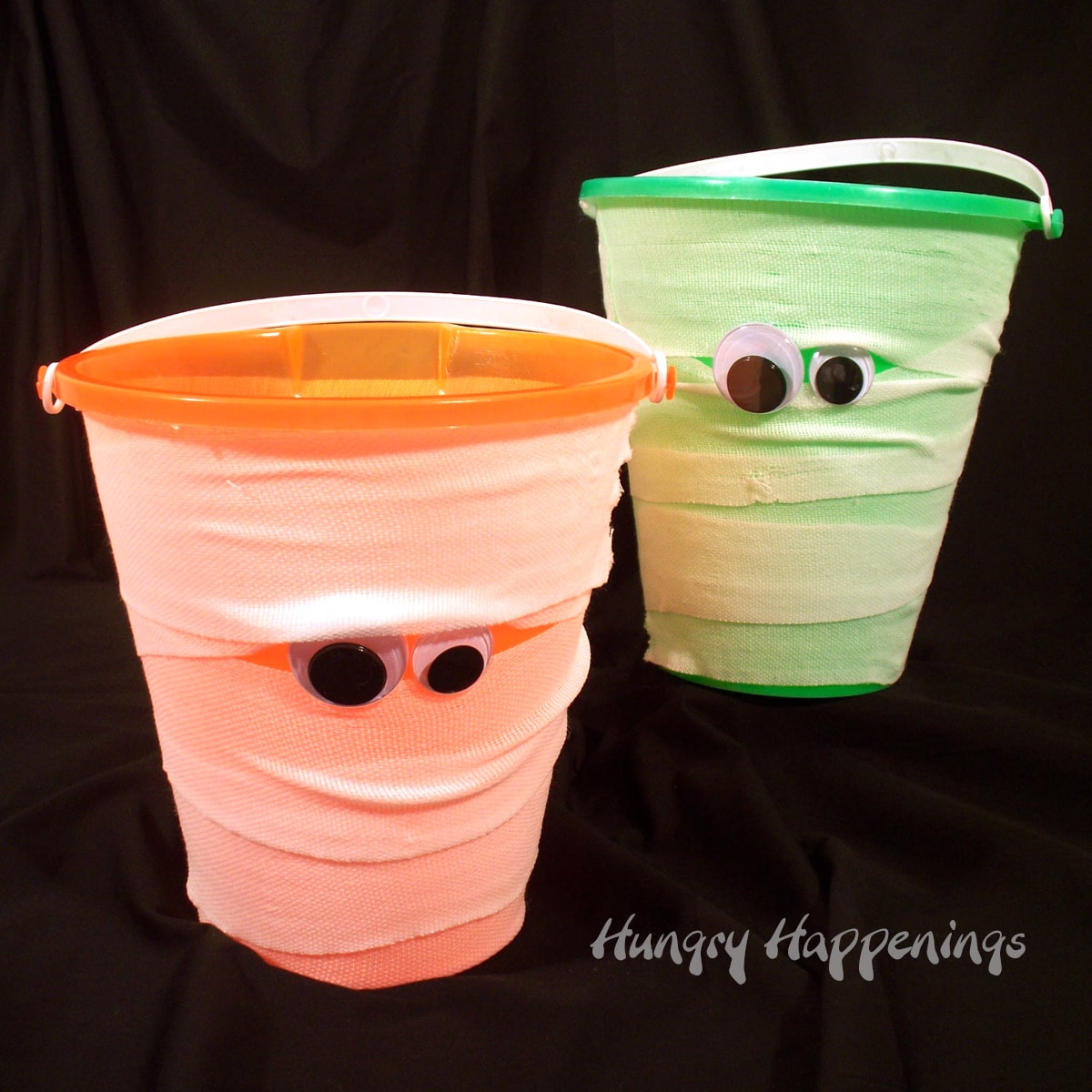 mummy buckets wrapped in gauze with googly eyes.