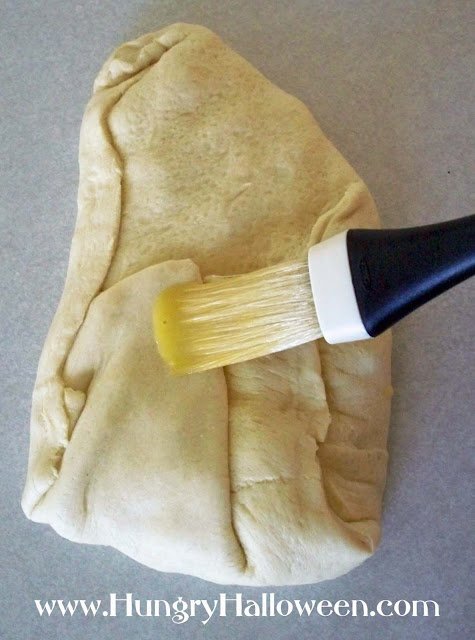 brushing butter over the dough.