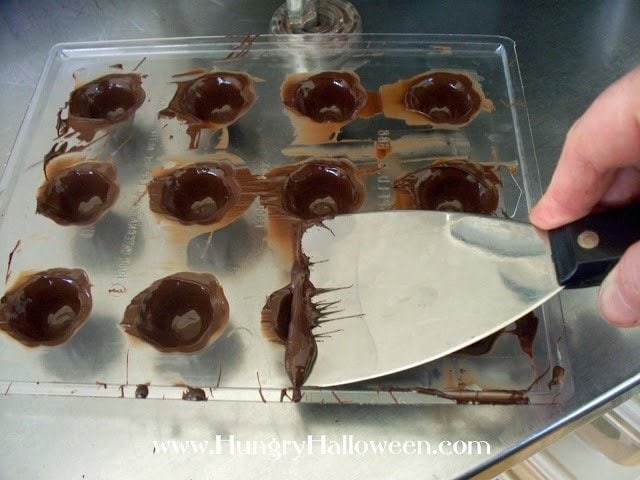 scraping the chocolate off the candy mold. 
