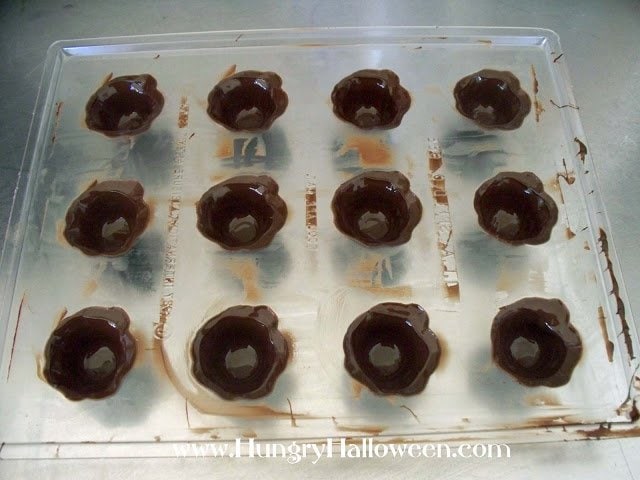 pumpkin candy mold filled with melted chocolate shells. 