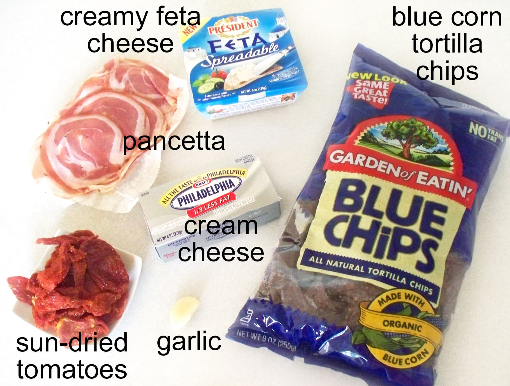 cheese ball witch hat ingredients including pancetta, creamy feta cheese, cream cheese, sun-dried tomatoes, garlic, and blue corn tortilla chips.