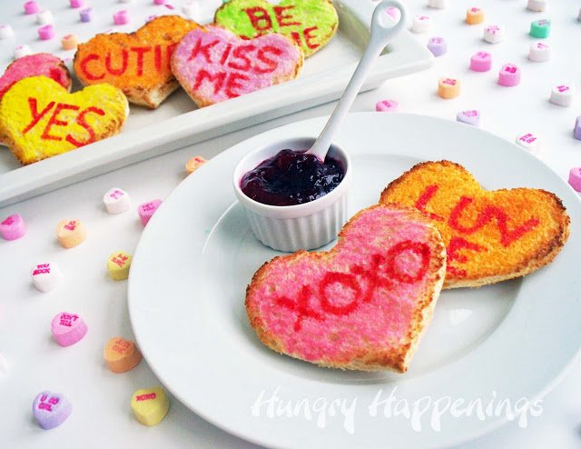 brightly colored conversation heart toast served with jelly surrounded by conversation heart candies