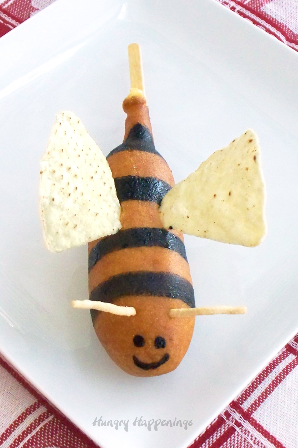 a corn dog decorated to look like a bumble bee.