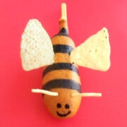 corn dog bumble bee with tortilla chip wings, black food coloring stripes, and potato stick antennae