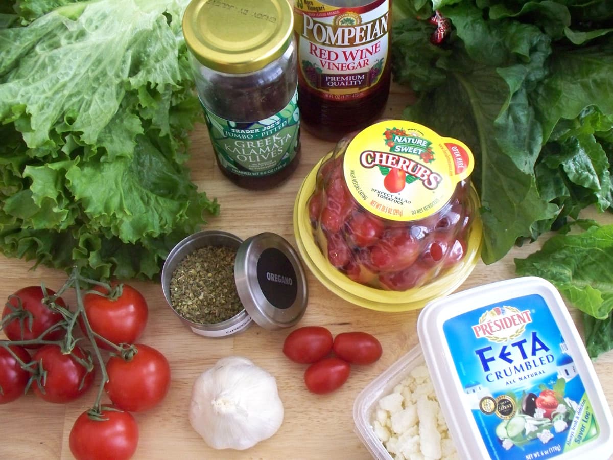 Mediterranean salad ingredients including feta cheese, olives, and tomatoes.