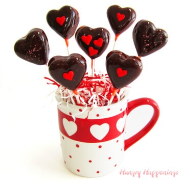 homemade cherry tootsie pop hearts arranged in a Valentine's day coffee mug