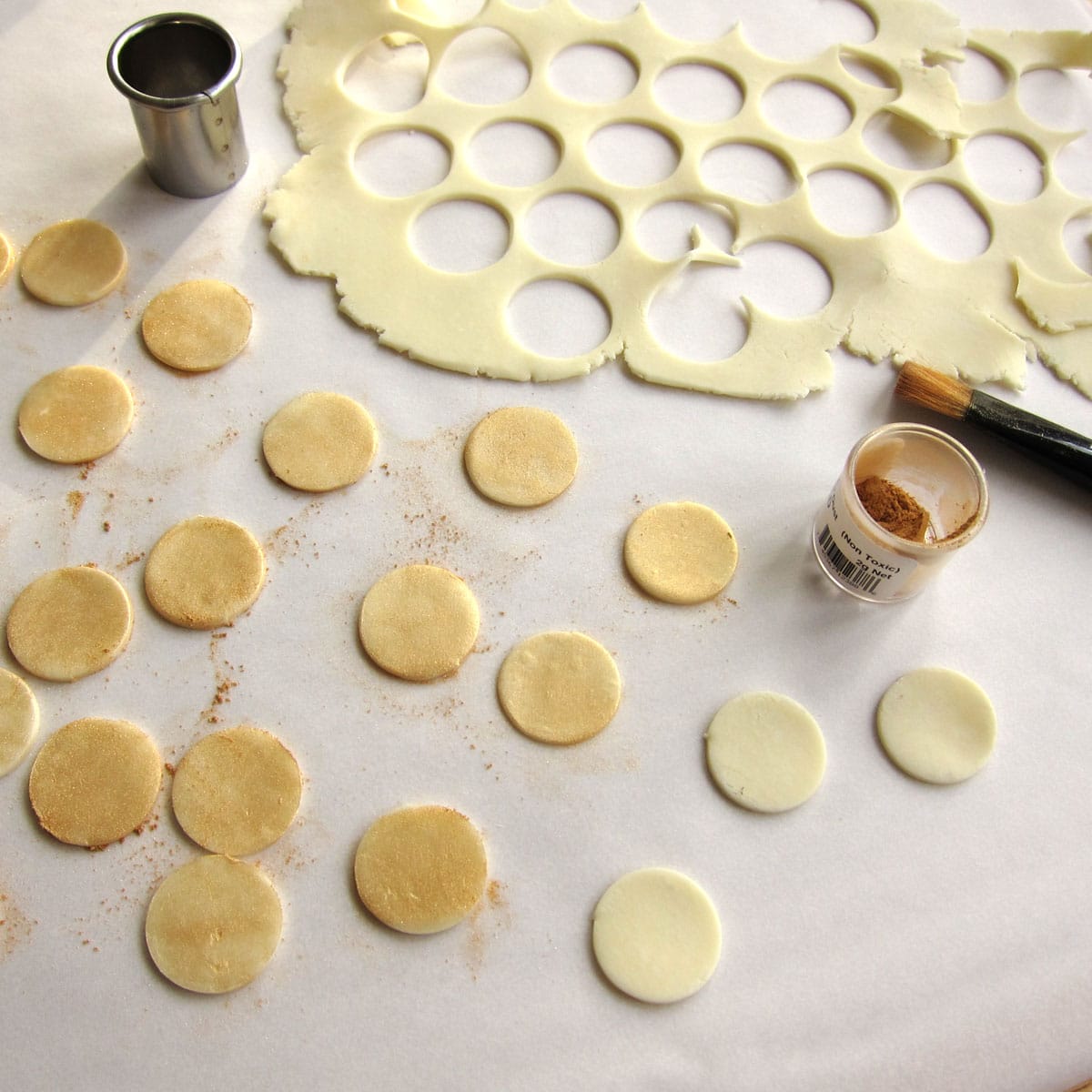 making gold coins out of white modeling chocolate and gold luster dust.