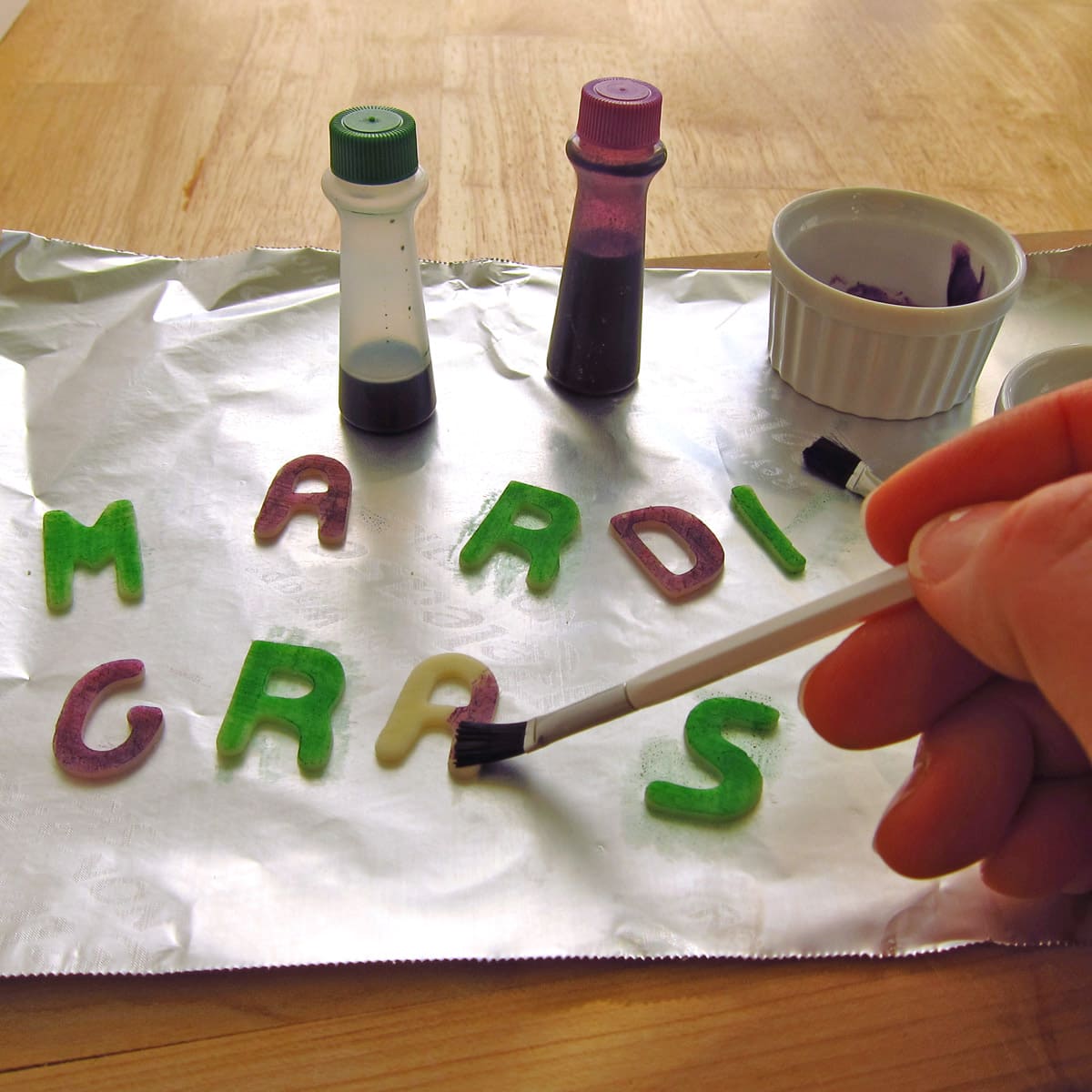 brush food coloring over the cut-out mozzarella cheese letters