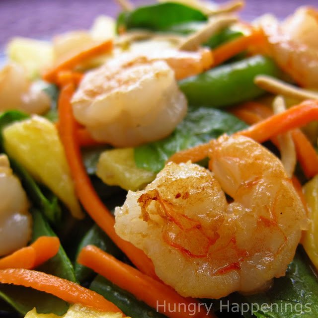 closeup of seared shrimp in the spinach salad. 