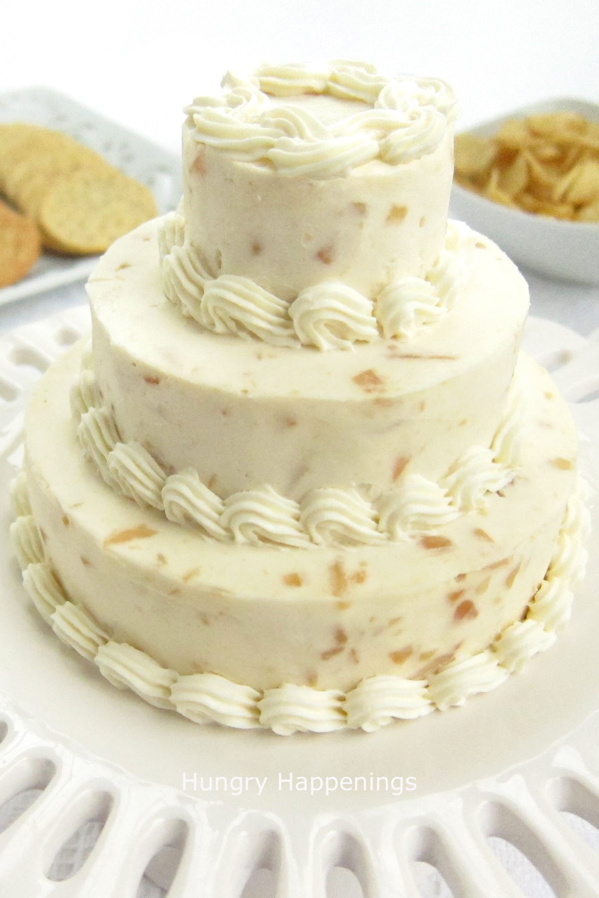 a wedding cake cheese ball decorated with cream cheese piped border. 
