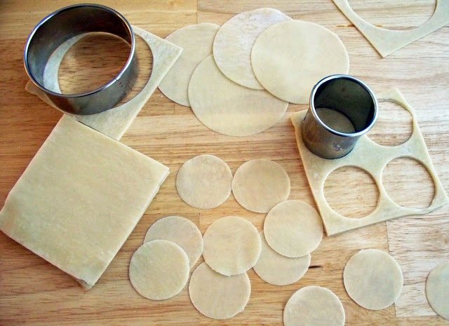cutting circles out of won ton wrappers using round cookie cutters.