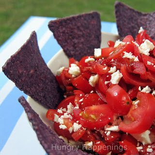 a bowl of Mediterranean tomato salsa with feta cheese served with blue corn tortilla chips