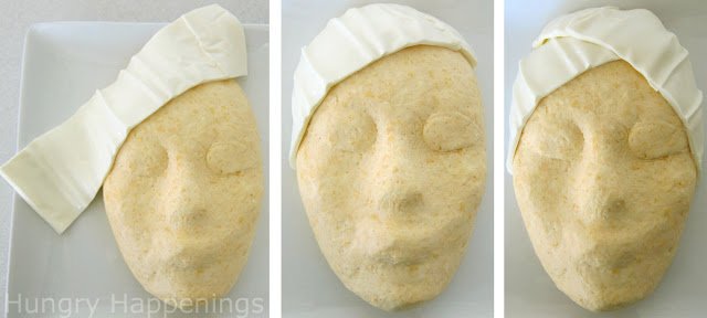 cheese ball face wrapped with a mozzarella cheese towel.
