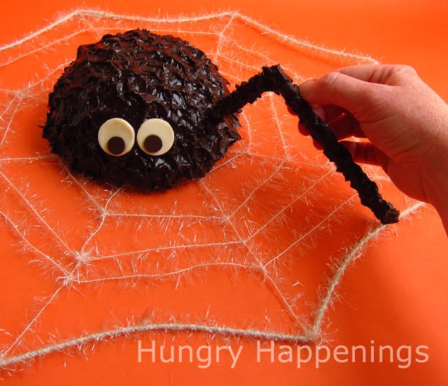 Insert a chocolate spider leg into the spider cake. 