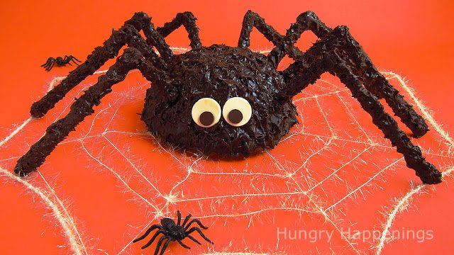 Giant chocolate cake ball spiders with modeling chocolate eyes and chocolate legs.