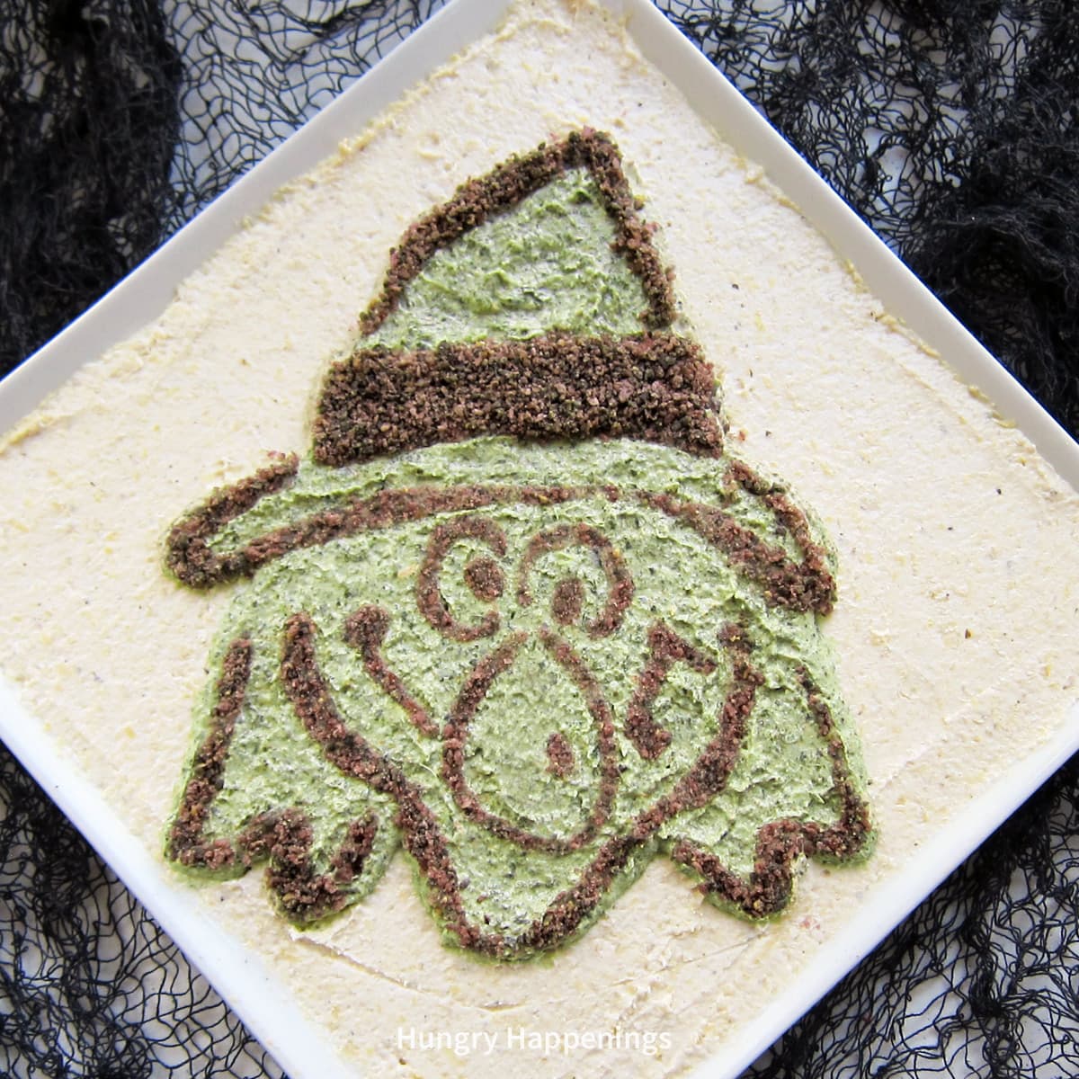 Halloween spinach and artichoke dip decorated with a witch