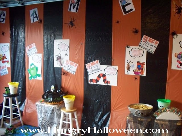Halloween carnival created with orange and black striped walls and printed signs. 
