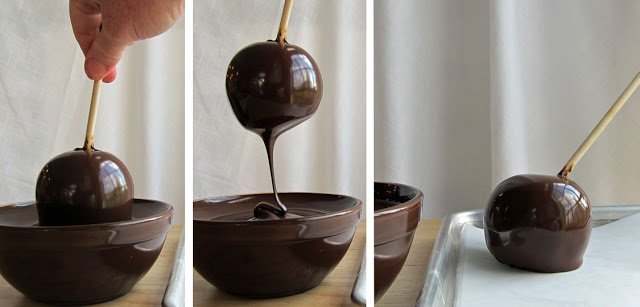 dipping a caramel apple in melted chocolate. 