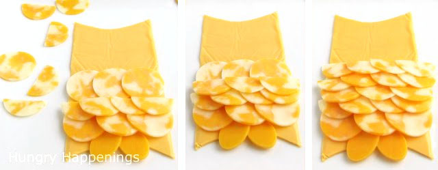 Cut circles out of co-jack cheese and start creating layers of the owl's feathers. Cut some circles of cheese in half and continue to layer them over the round cheese feathers. 