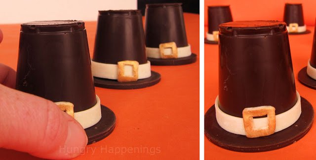 small dark chocolate pilgrim hats decorated with white chocolate hat bands and buckles. 