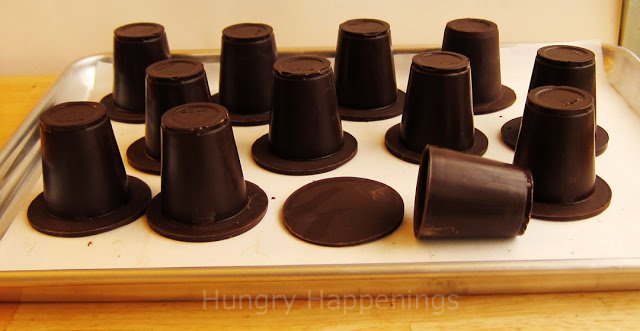 attaching the chocolate brims to the chocolate cups to create pilgrim hats. 