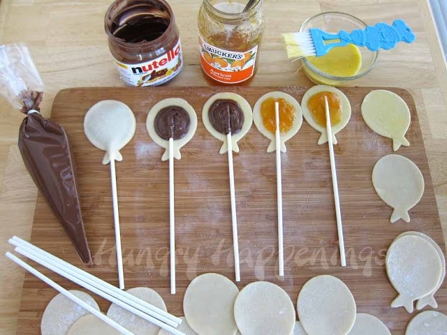 fill the balloon-shaped pie crust with Nutella or jam, then insert a lollipop stick