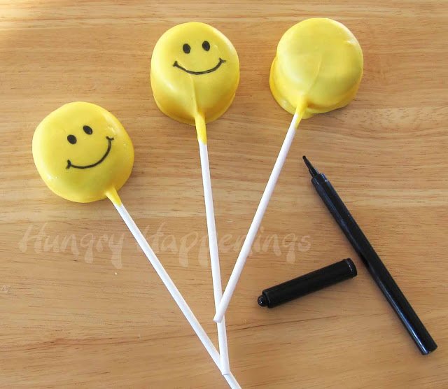 smiley faces drawn on yellow lollipops