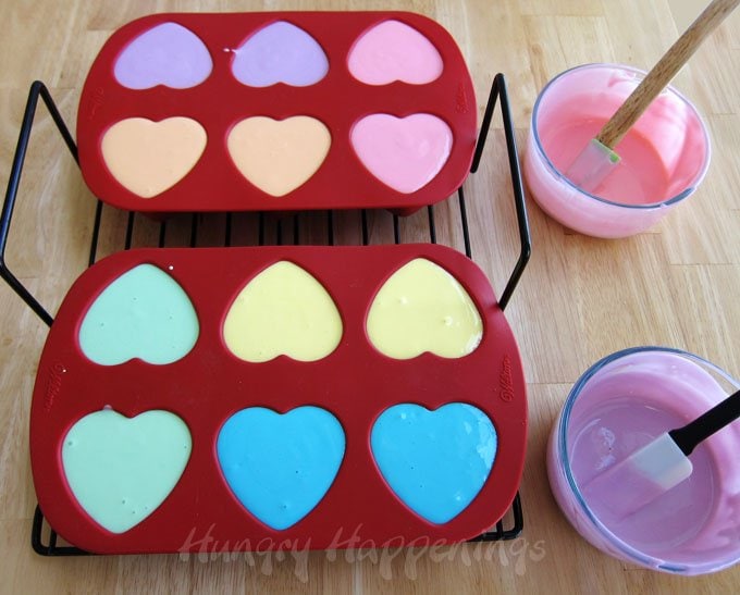 Fill a heart shaped silicone mold with colorful cheesecake filling and turn them into Conversation Heart Cheesecakes. 