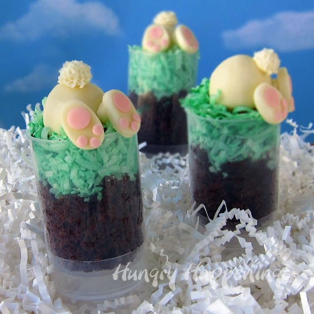 push-up pop containers filled with chocolate cake, green-colored coconut, and white chocolate bunnies.