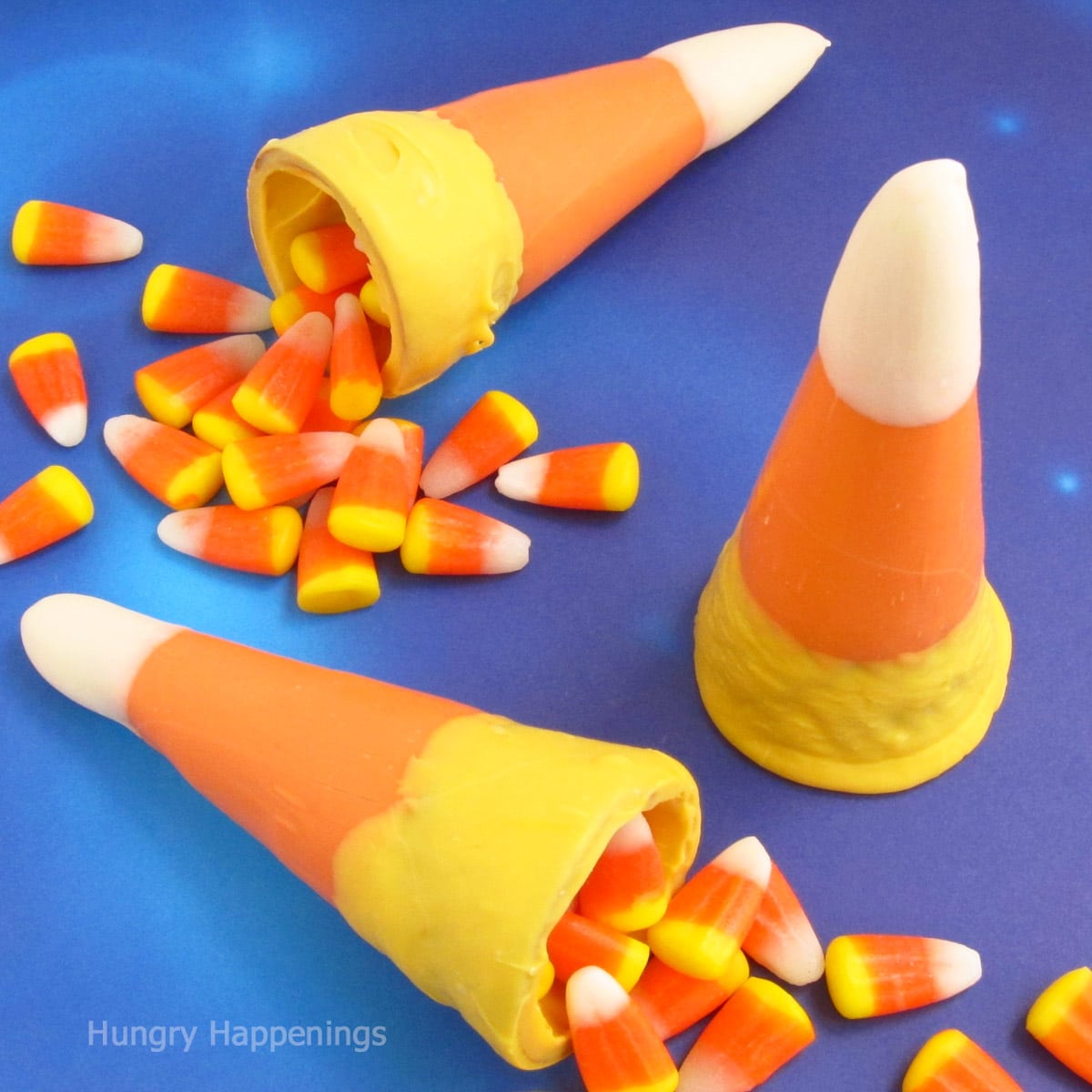 candy corn cones made with sugar cones dipped in white, yellow, and orange candy melts.