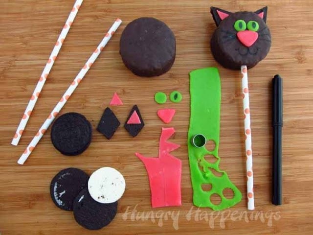 decorating chocolate snack cake cats using pink and green Air Heads taffy and a black food coloring marker.