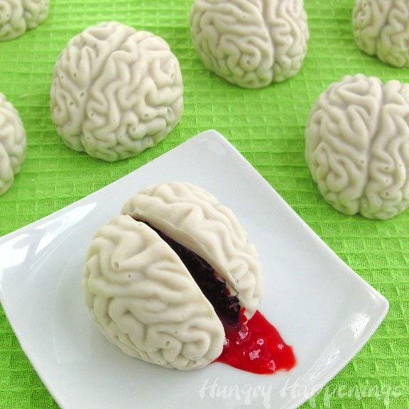 white chocolate cake ball brains are filled with a blend of chocolate cake and vanilla frosting and bloody raspberry jam