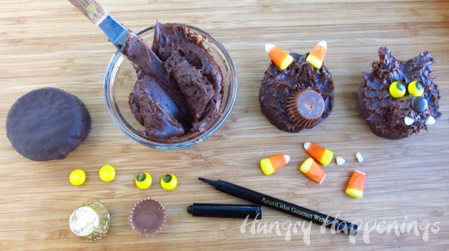 making werewolf snack cakes using Ding Dongs, frosting, Reese's Cup miniatures, yellow M&Ms, candy corn, and black food coloring marker. 