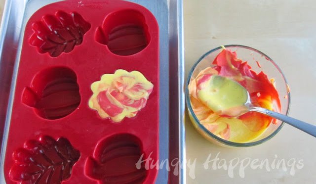 leaf-shaped silicone mold filled with swirled red, yellow, and orange cheesecake filling. 