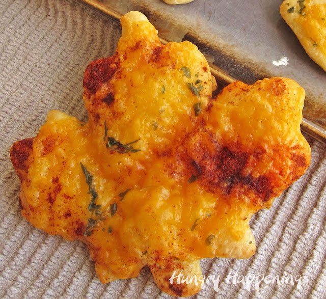 one cheese-topped crescent roll leave sprinkled with paprika and parsley.