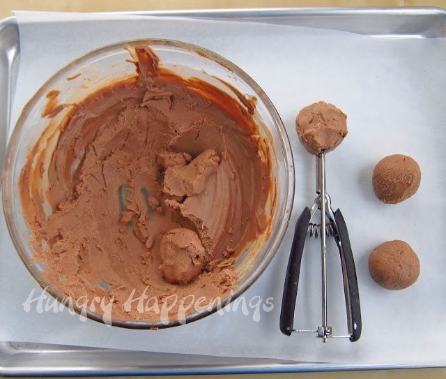 scooping peanut butter chocolate fudge into balls.