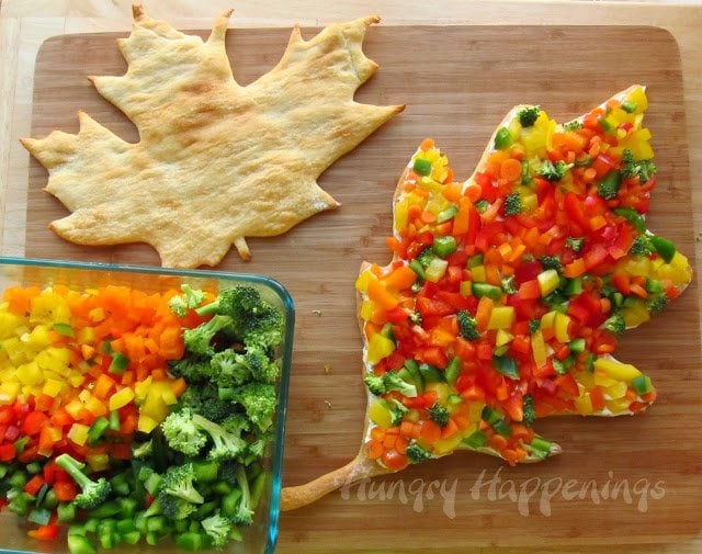 one veggie pizza leaf topped with red, green, yellow, and orange peppers, carrots, and broccoli. 