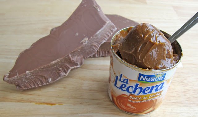 a can of Nestle La Lechera Dulce de Leche with blocks of milk chocolate. 