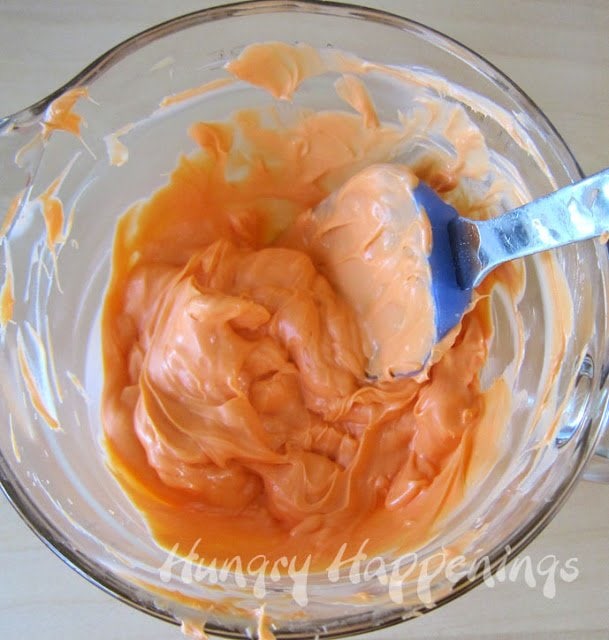 stirring melted orange candy melts. 