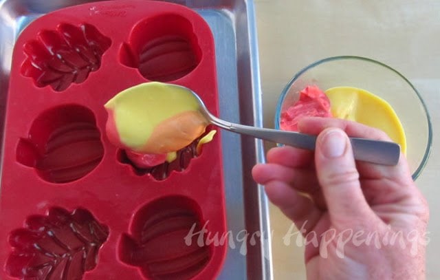 pouring swirled orange, red, and yellow cheesecake filling into a leaf-shaped silicone mold. 
