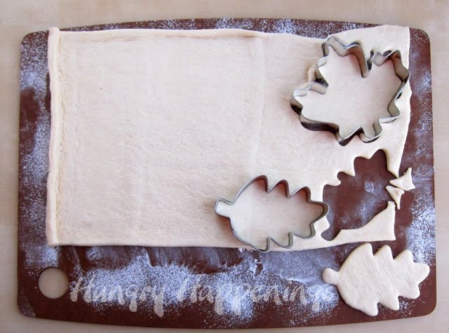 cutting crescent dough using leaf-shaped cookie cutters. 