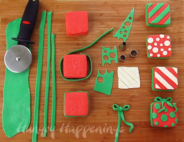decorating red Christmas present cookies using green modeling chocolate stripes and ribbons and white polka dots and stripes. 