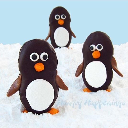 Turn store bought cookies into adorably cute Dark Chocolate Nutter Butter Penguins with Marshmallow Bellies. They are so fun to make using marshmallows, candy eyes, and Tootsie Rolls.