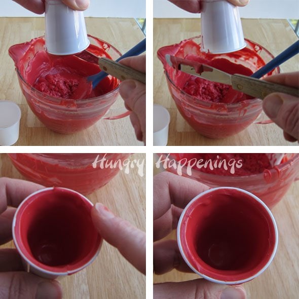scraping off excess red candy melts from the top edge of a plastic cup. 