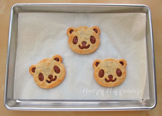 Panda bear pastries baked on a parchment paper-lined baking sheet. 