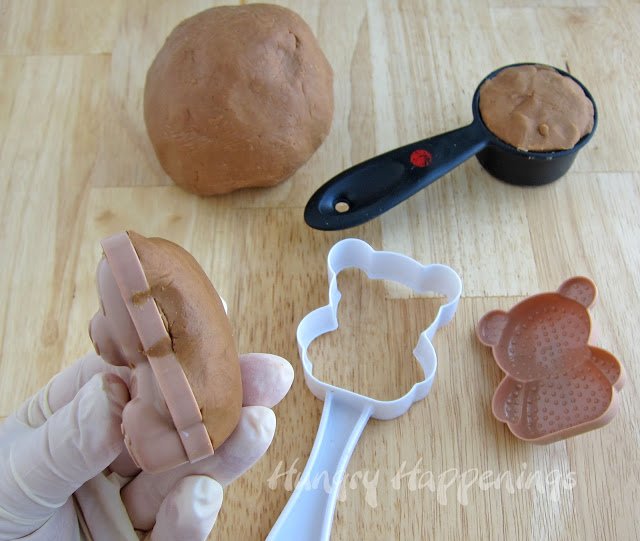 pressing chocolate caramel fudge into a teddy bear rice mold. 