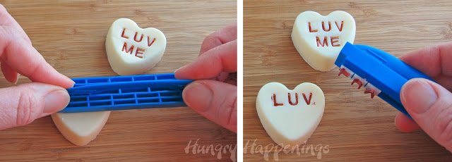 imprinting a white fudge conversation heart with "LUV ME"