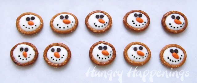 round pretzel snowmen heads decorated with orange candy-coated sunflower seed noses and mini chocolate chip eyes. 
