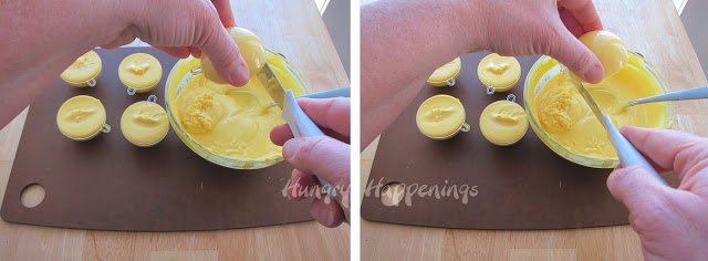 scraping off the excess yellow candy melts around the top edge of a plastic round ornament mold. 