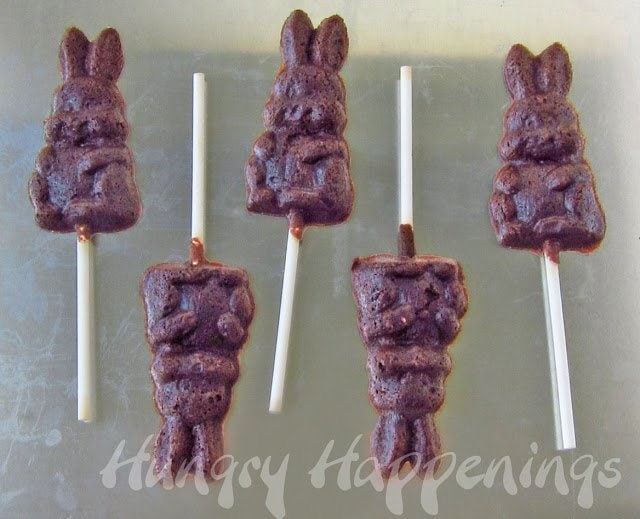 chocolate bunny cookie lollipops cooling on a cookie sheet. 